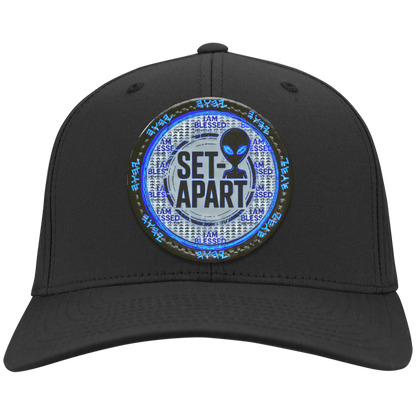 Black cap with a circular design featuring text and an alien figure on a white background.