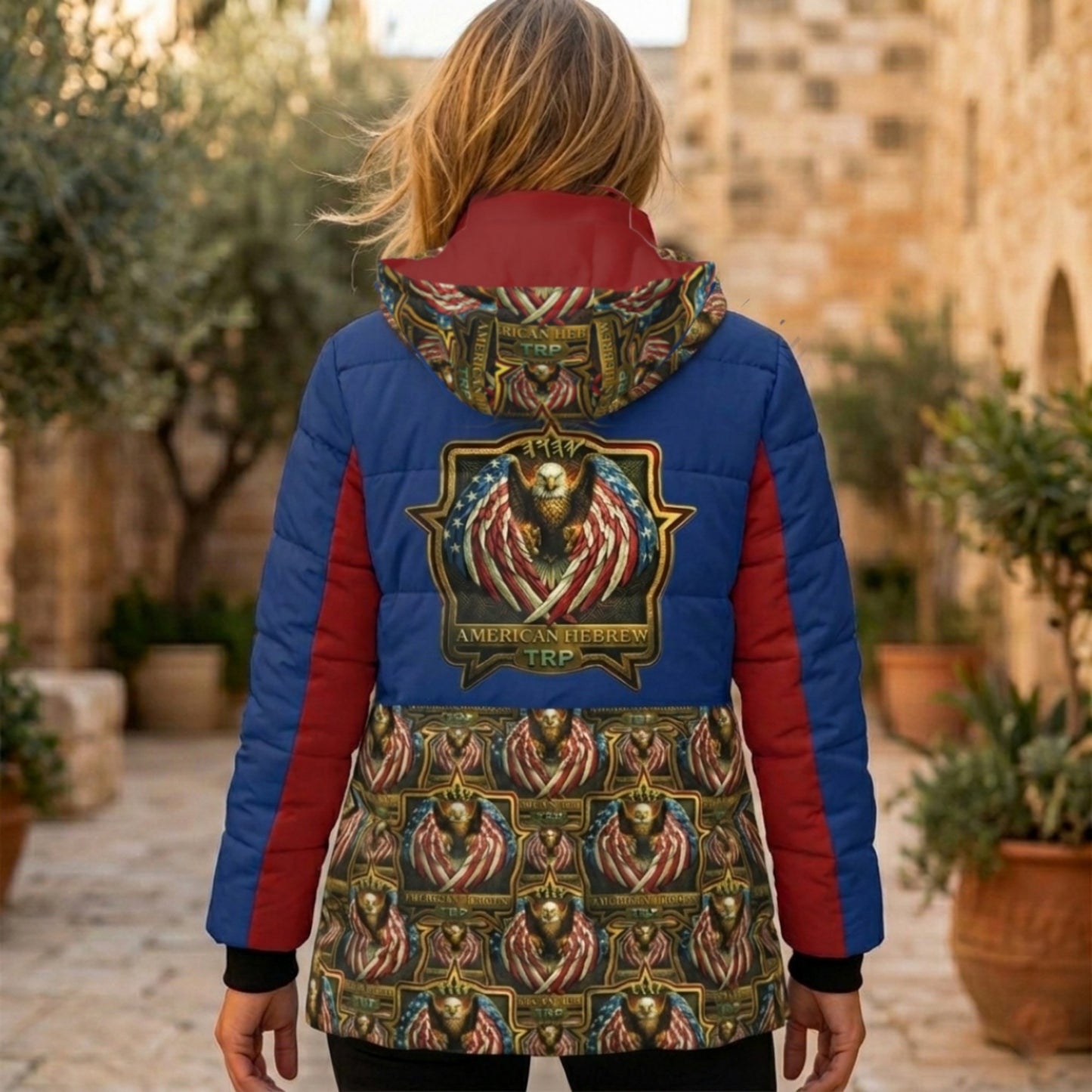 Back of a blue and red puffer jacket featuring a large "American Hebrew TRP" eagle crest and a matching patterned lower panel and hood.