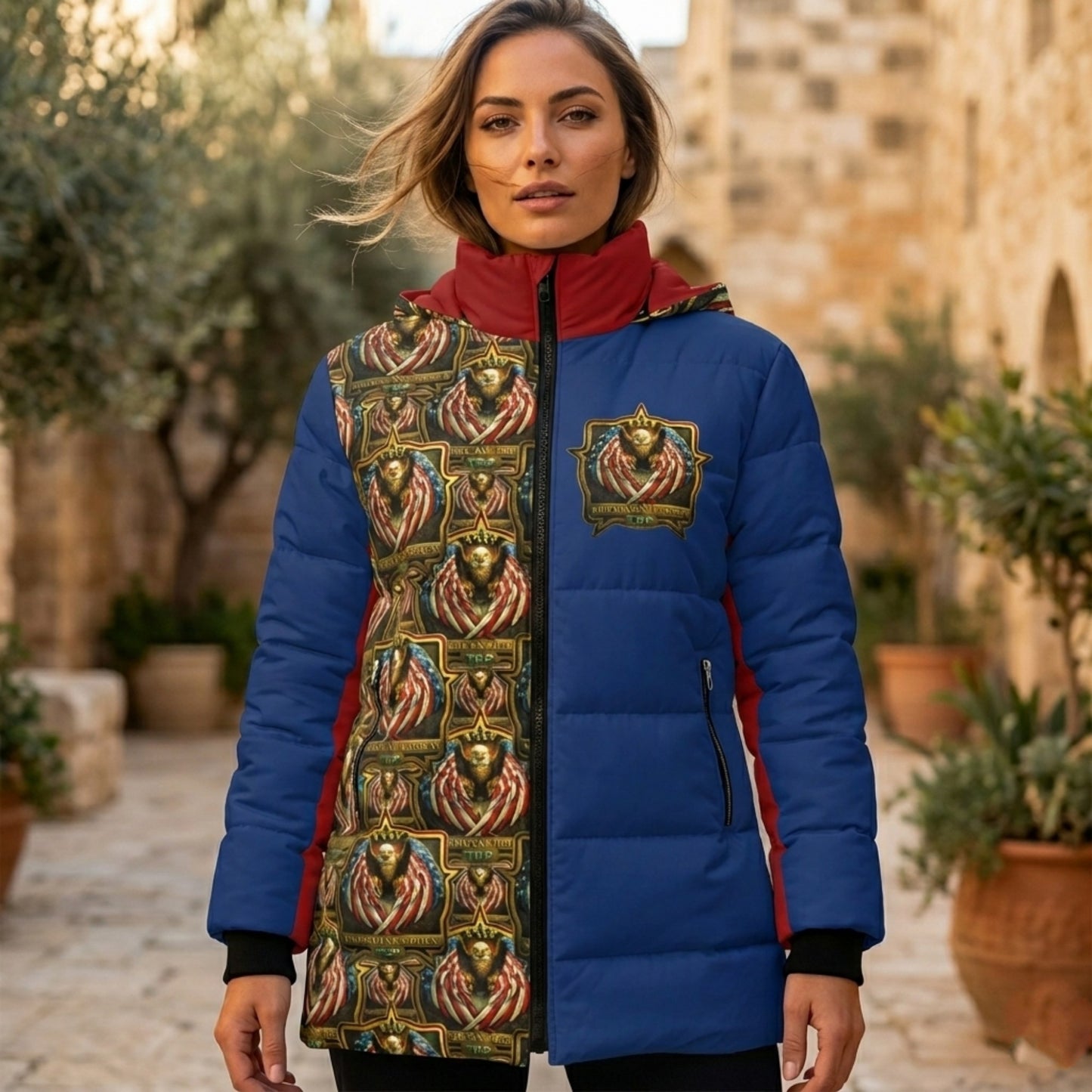 Woman in a blue and red puffer jacket with an "American Hebrew TRP" eagle emblem and a repetitive eagle pattern on one side, set in a stone courtyard.