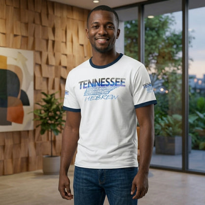 A smiling man wears a white ringer tee with a blue "Tennessee Hebrew" graphic featuring the state silhouette filled with script.