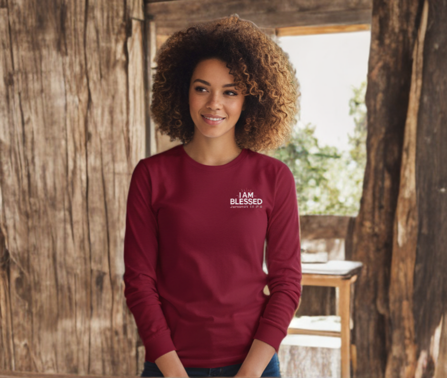 Woman wearing a red long-sleeve shirt with 'I AM BLESSED' text, standing in a rustic outdoor setting.
