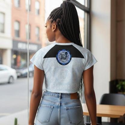 Rear view of a woman wearing a light blue patterned crop top with a small "SET-APART" alien logo on a black panel between the shoulders.